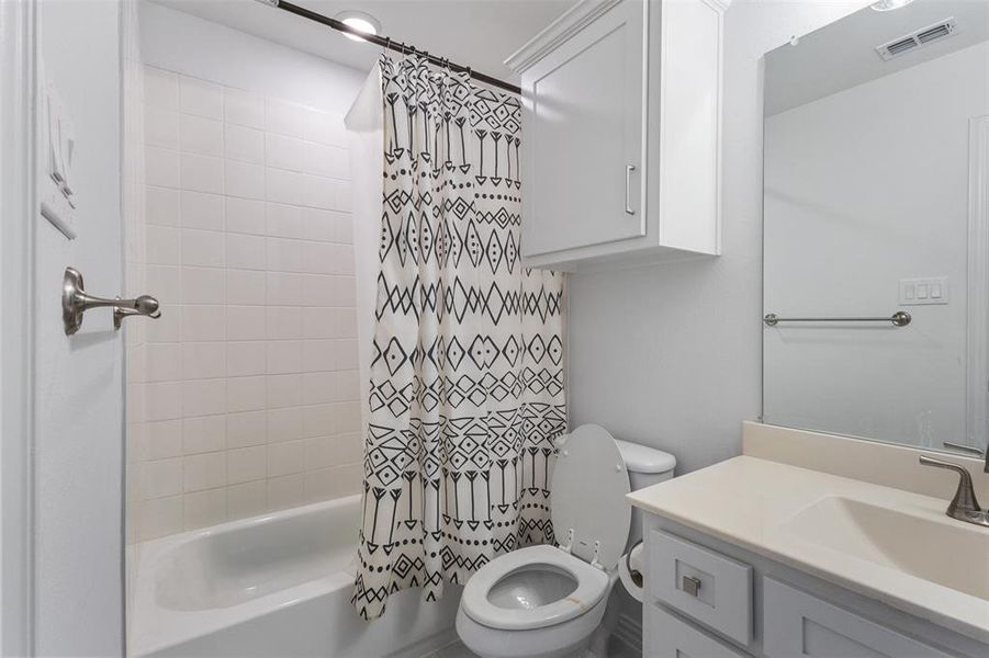 Bathroom with shower / bathtub combination with curtain and vanity