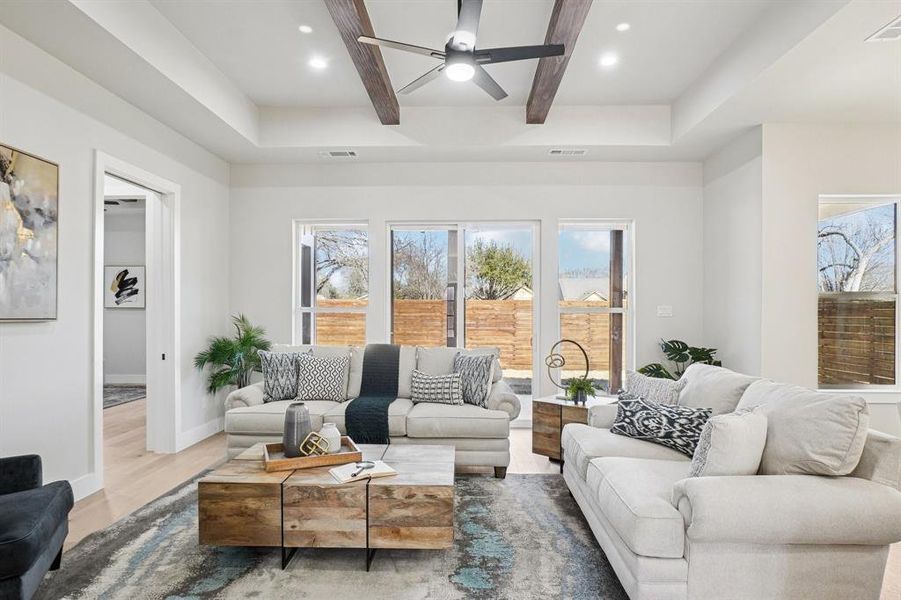 Living room with ceiling fan, recessed lighting, wood finished floors, and beam ceiling