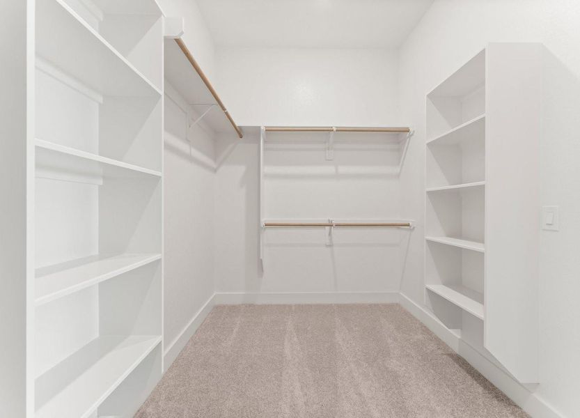The primary spacious walk-in closet features ample shelving and hanging space for an organized closet.