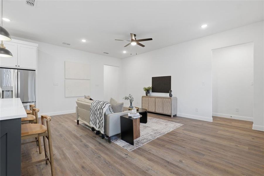 Living area featuring dark wood-style flooring, recessed lighting, and a ceiling fan