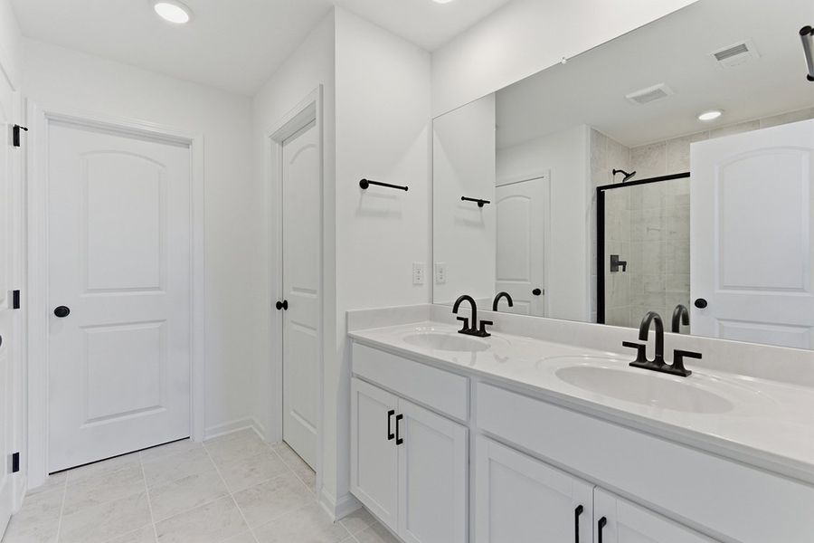 A bathroom with white cabinets.