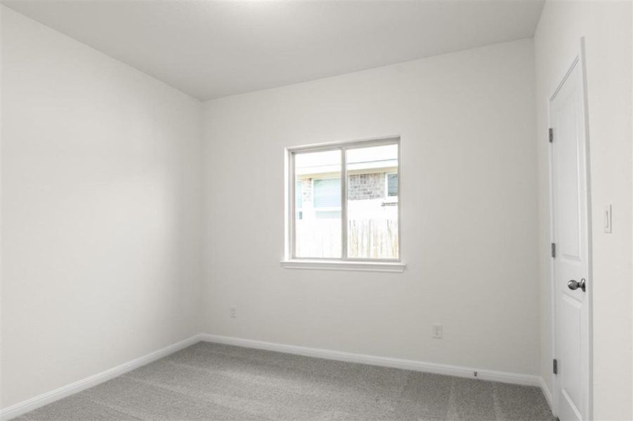 Carpeted empty room with baseboards