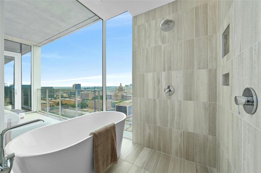 The primary bathroom features a bathtub with tiles that resemble wood, adding a touch of natural elegance. It includes a separate shower area and a panoramic view window with a glass panel, offering scenic vistas and enhancing the bathroom's ambiance. The primary bathroom features a bathtub with tiles that resemble wood, adding a touch of natural elegance. It includes a separate shower area and a panoramic view window with a glass panel, offering scenic vistas and enhancing the bathroom's ambiance.