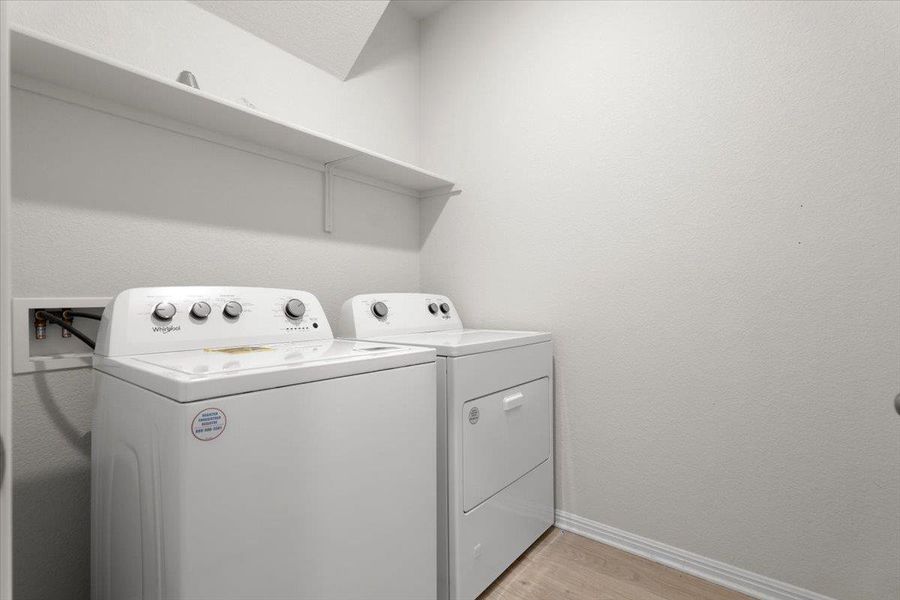 Dedicated laundry area featuring a white top-load washing machine and front-load dryer