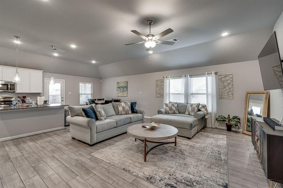 Living room featuring ceiling fan, light wood-type flooring, and plenty of natural light