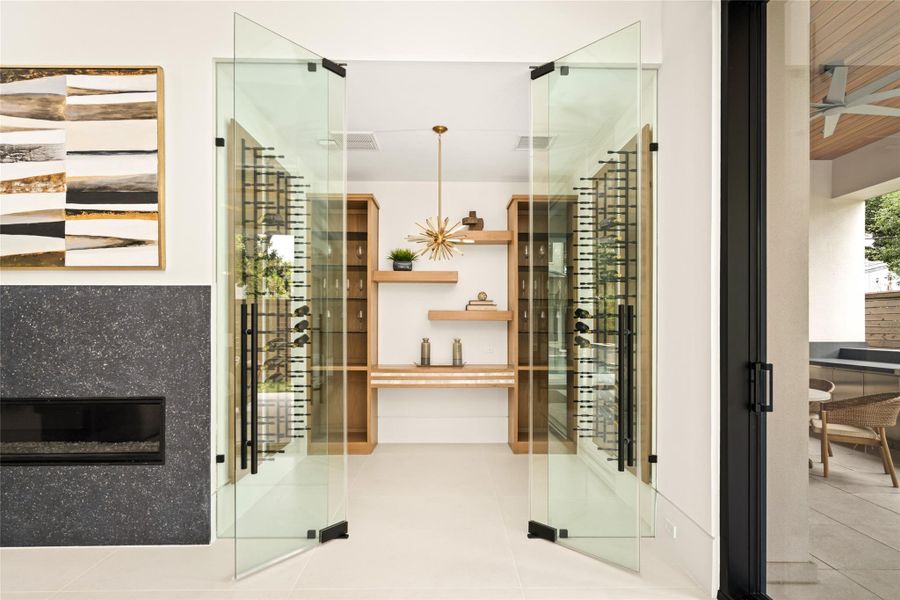 Climate-controlled wine room positioned off the living area, designed for easy access and a striking visual display.