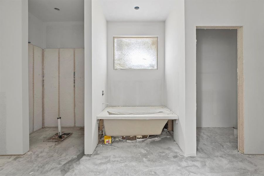 Bathroom under construction featuring a built-in tub basin and an adjacent shower enclosure Bathroom under construction featuring a built-in tub basin and an adjacent shower enclosure