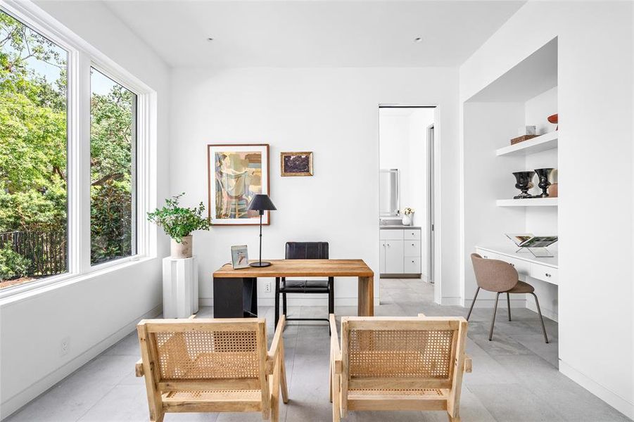 This bright and airy study features large windows that invite natural sunlight, clean lines and a comfortable workspace with built-in shelving for organization. A full bath and walk-in closet offer the option to convert this room into a fifth bedroom, making it a versatile addition to the home.