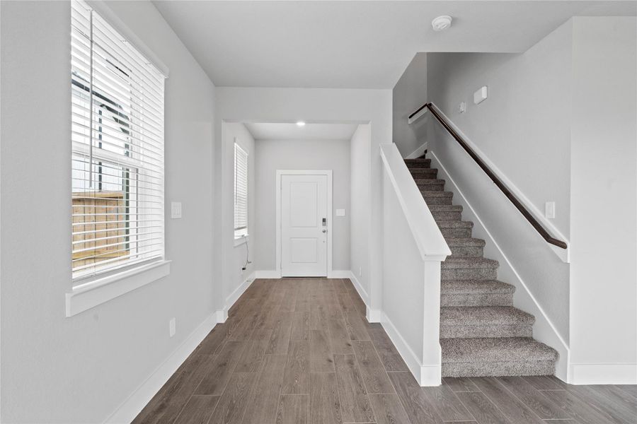 The wide entryway immediately highlights the spacious, open floor plan, leading past a staircase into a living space filled with natural light. The wide entryway immediately highlights the spacious, open floor plan, leading past a staircase into a living space filled with natural light.