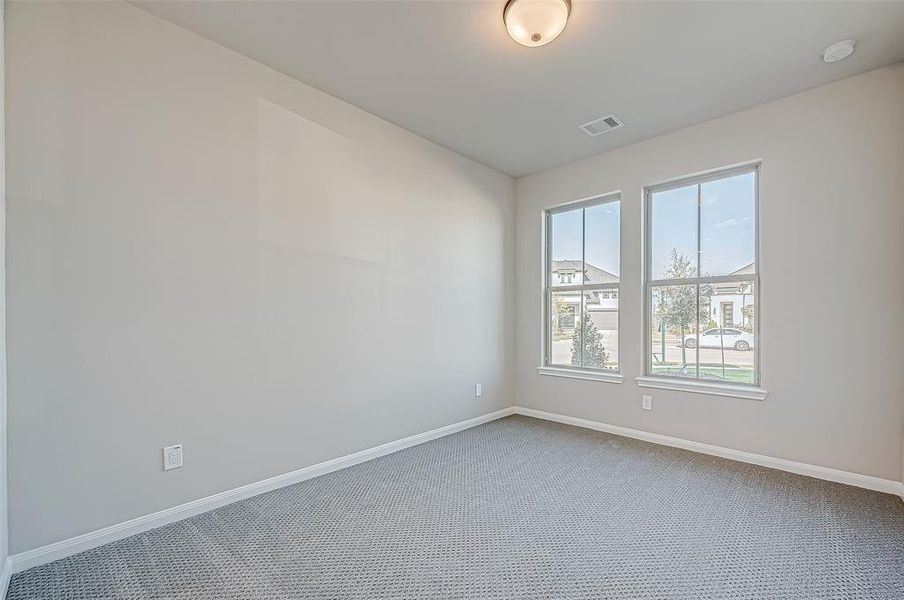 Two secondary bedrooms (Pictured 2 of 2) are located at the front of the home, offering walk-in closets and elegantly designed bathrooms with white marbled tile flooring, mud-set walk-in showers with benches, and black granite countertops with gold hardware.