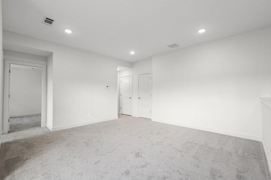 Carpeted empty room featuring recessed lighting and baseboards