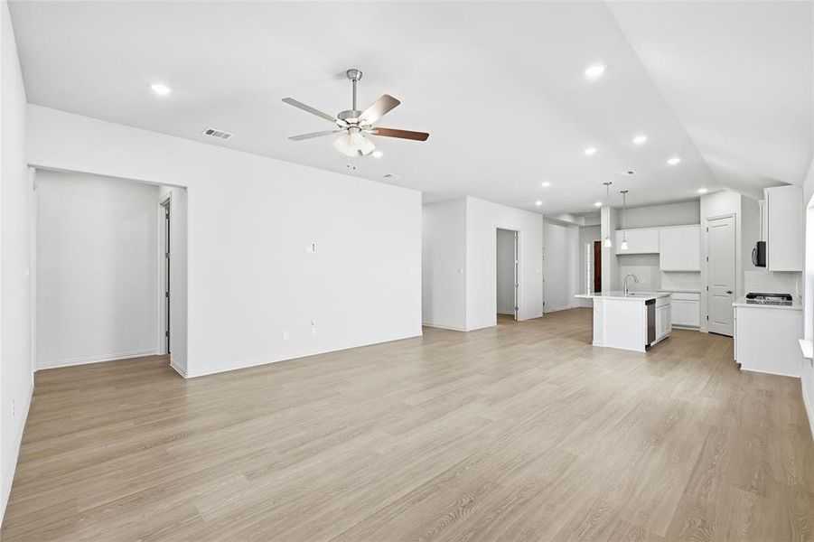 Unfurnished living room featuring light wood-style floors, ceiling fan, and recessed lighting