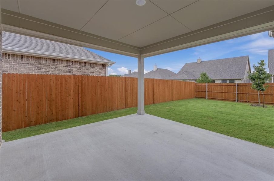 Expansive covered patio with a concrete surface, providing a spacious outdoor living area