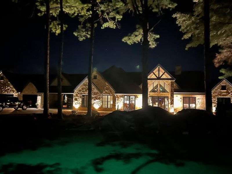Front of house at night with stone siding