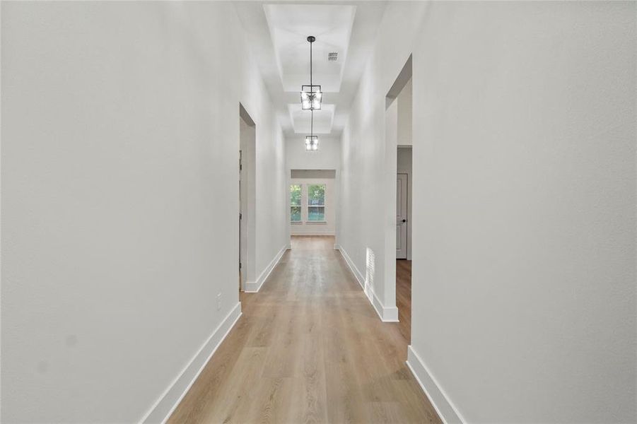 Hallway featuring light wood finished floors and baseboards