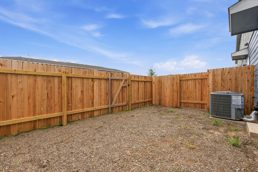 Private backyard with wood fencing and an exterior HVAC unit Private backyard with wood fencing and an exterior HVAC unit