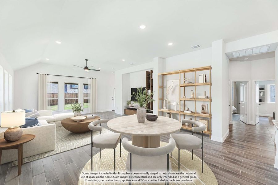 Open-concept living and dining area with wood-look floors, vaulted ceiling, ceiling fan, and round dining table with neutral decor