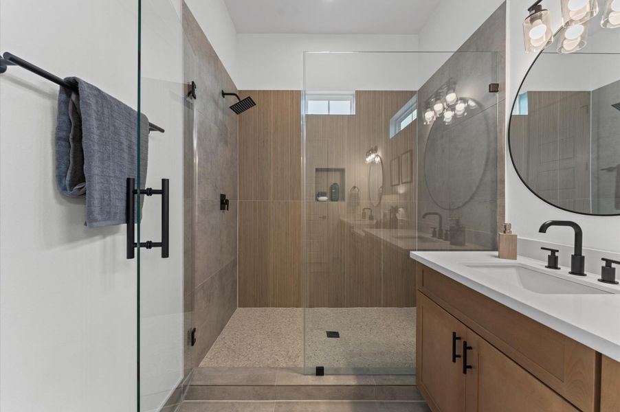 This stylish primary bathroom showcases a spacious walk-in shower framed with sleek glass panels and modern tilework that adds texture and sophistication. A double sink vanity anchors the space with clean lines and ample countertop room, complemented by an abundance of cabinetry that offers both function and flair. Contemporary finishes tie the room together, creating a polished retreat that balances luxury with everyday practicality. This stylish primary bathroom showcases a spacious walk-in shower framed with sleek glass panels and modern tilework that adds texture and sophistication. A double sink vanity anchors the space with clean lines and ample countertop room, complemented by an abundance of cabinetry that offers both function and flair. Contemporary finishes tie the room together, creating a polished retreat that balances luxury with everyday practicality.
