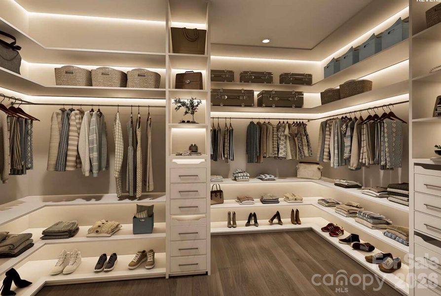 This expansive walk-in closet offers a boutique-style layout with custom built-ins, open shelving, and ample hanging space for effortless organization. This expansive walk-in closet offers a boutique-style layout with custom built-ins, open shelving, and ample hanging space for effortless organization.
