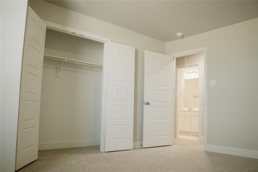 Unfurnished bedroom featuring a closet and light colored carpet