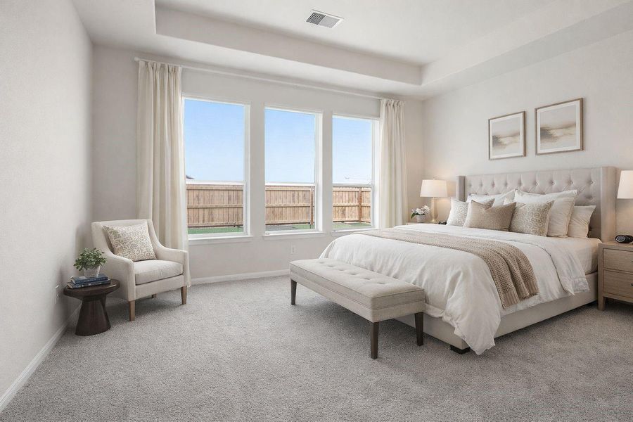 Spacious primary bedroom retreat featuring soft natural light, plush carpet flooring, and a tray ceiling that adds depth and elegance, creating a peaceful space to relax at the end of the day. **Virtually Staged** Spacious primary bedroom retreat featuring soft natural light, plush carpet flooring, and a tray ceiling that adds depth and elegance, creating a peaceful space to relax at the end of the day. **Virtually Staged**