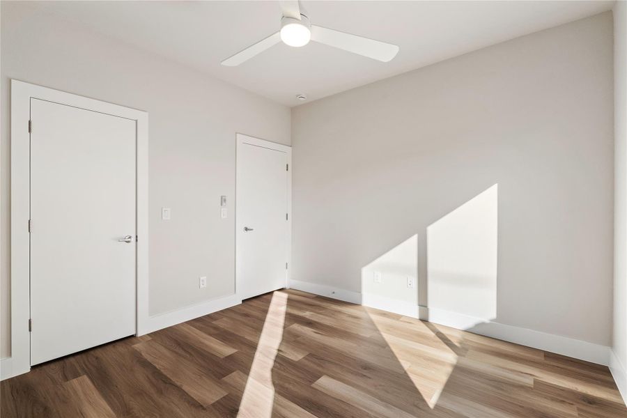 A second look at the guest bedroom highlights the walk-in closet, ceiling fan, and a layout that comfortably supports everyday living.