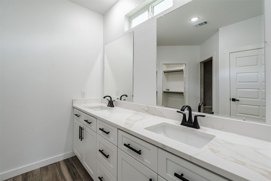 Double vanities with sleek black fixtures elevate this well-appointed bathroom. Double vanities with sleek black fixtures elevate this well-appointed bathroom.