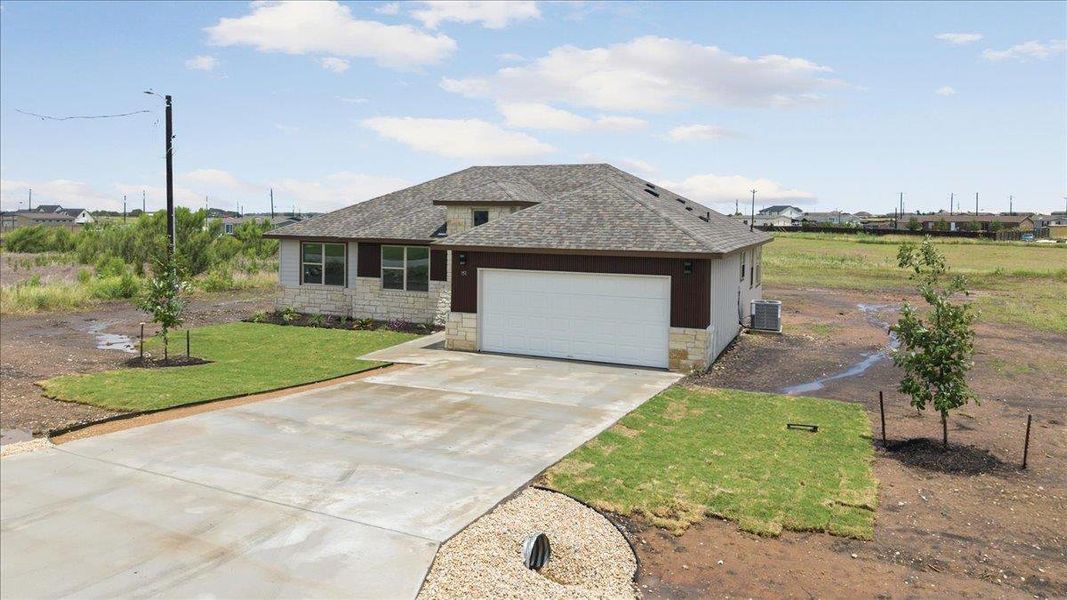 A newly constructed residence features a well-defined driveway leading to an attached 2 car garage. A newly constructed residence features a well-defined driveway leading to an attached 2 car garage.