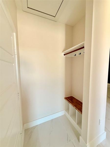 Mudroom with marble look tiles and baseboards