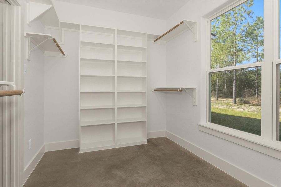 A large window brings in natural light, creating a bright and inviting space that makes selecting outfits feel effortless.