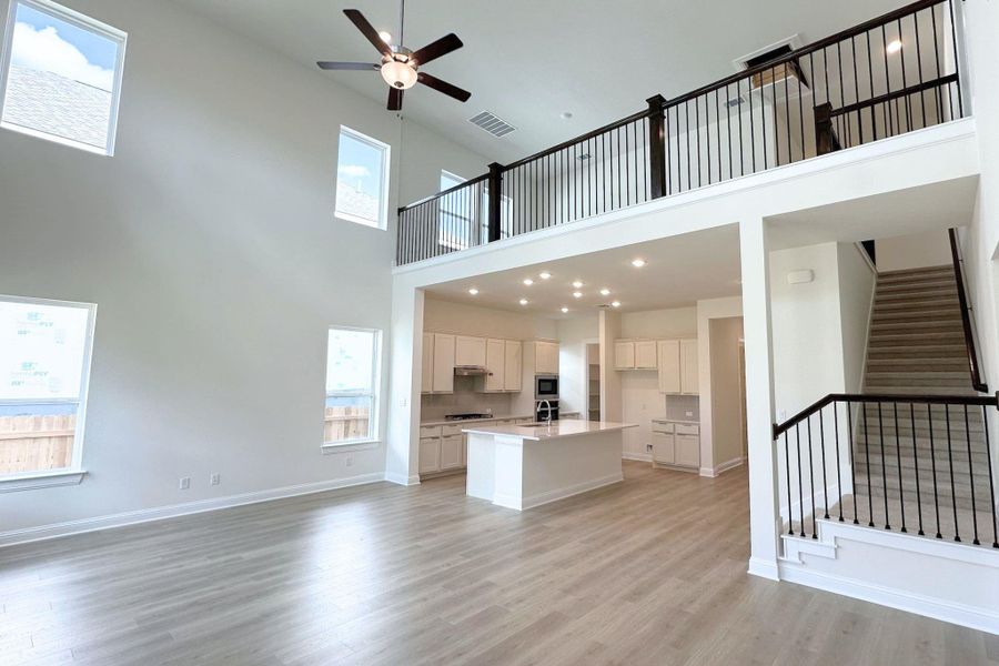 A spacious, open-concept interior highlights high ceilings and a modern kitchen with a large island.