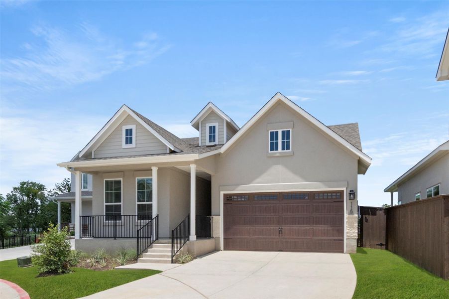 View of front of property featuring roof with shingles, concrete driveway, stucco siding, and covered porch