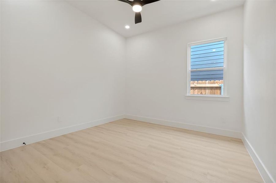 Bright room featuring light wood-finish flooring, white baseboards, and neutral wall paint