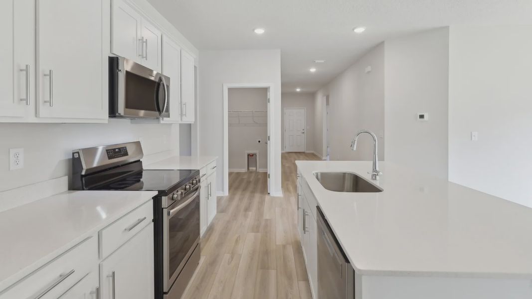 Elegant quartz countertops and stainless steel appliances enhance this Palm Coast kitchen's luxurious appeal.