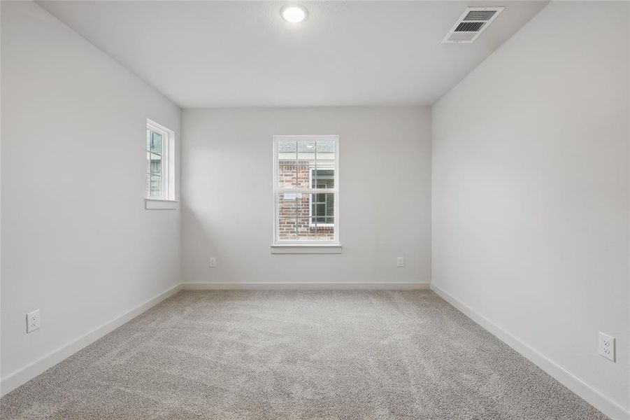 Spare room featuring light colored carpet and baseboards