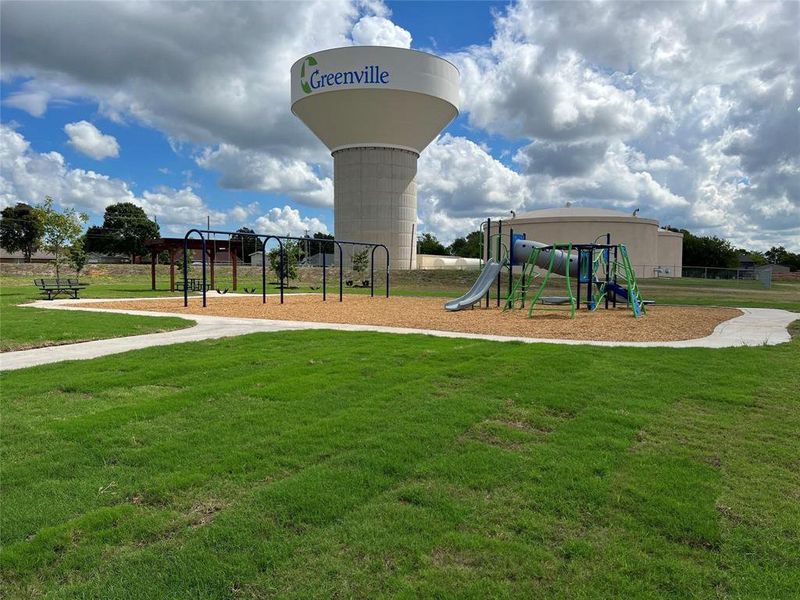 Outdoor playground featuring a slide, swings, and a bark-mulch surface