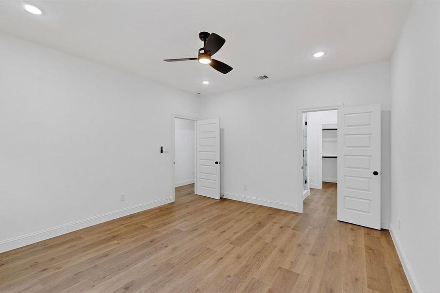 Unfurnished bedroom featuring light wood finished floors, recessed lighting, a ceiling fan, and a spacious closet Unfurnished bedroom featuring light wood finished floors, recessed lighting, a ceiling fan, and a spacious closet