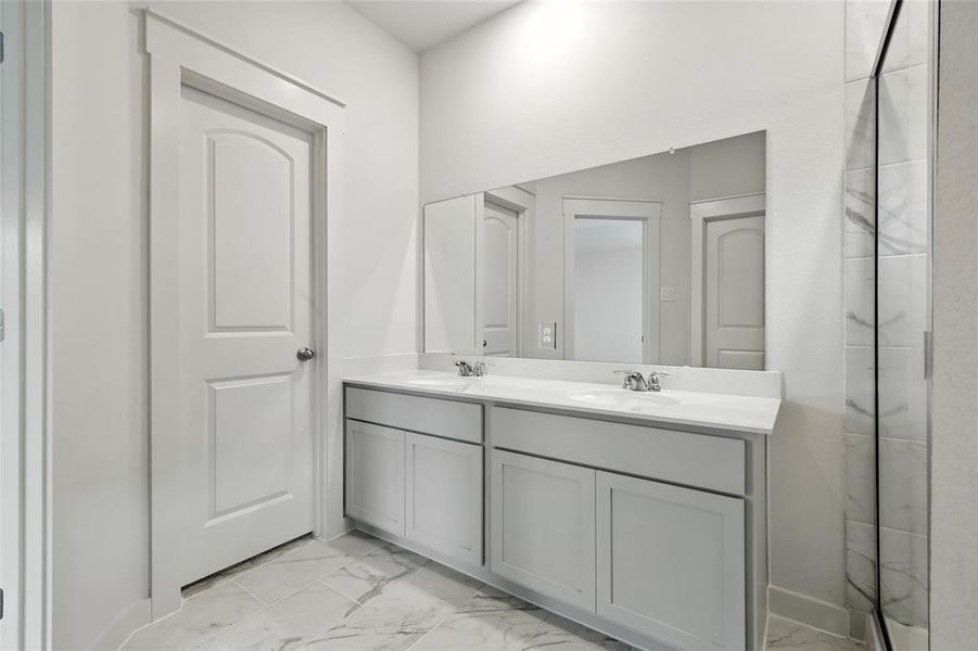 Bathroom with marble finish floors and double vanity