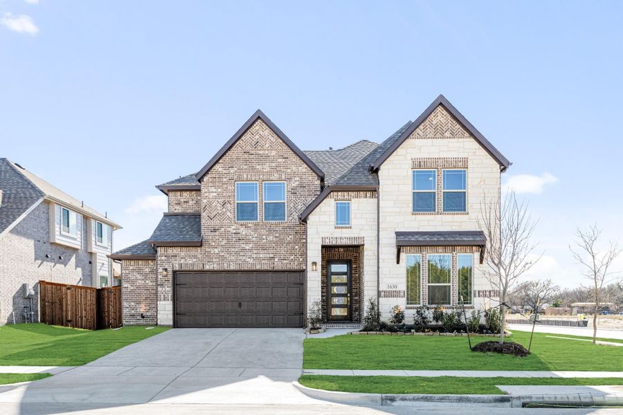 Two-story home with brick and stone exterior, two-car garage, and manicured front lawn Two-story home with brick and stone exterior, two-car garage, and manicured front lawn