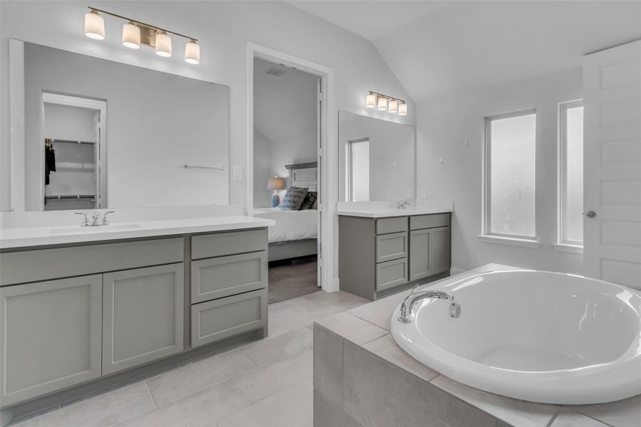 Relax in your primary bath with double vanity sinks, soaker tub, and standing showing.