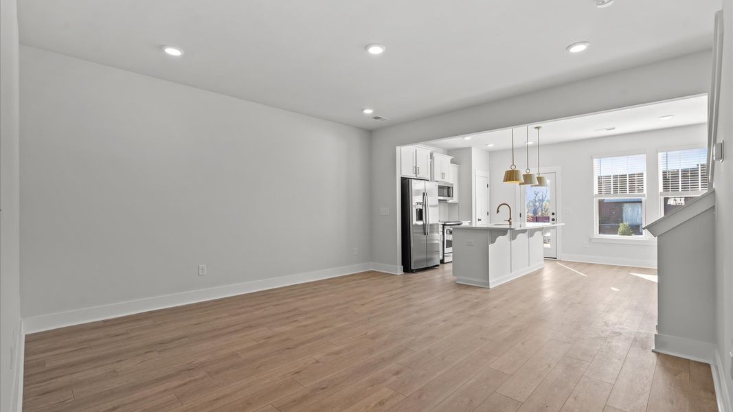 Spacious family room with rich hardwood flooring and elegant trim work in a reputable DRB Homes build