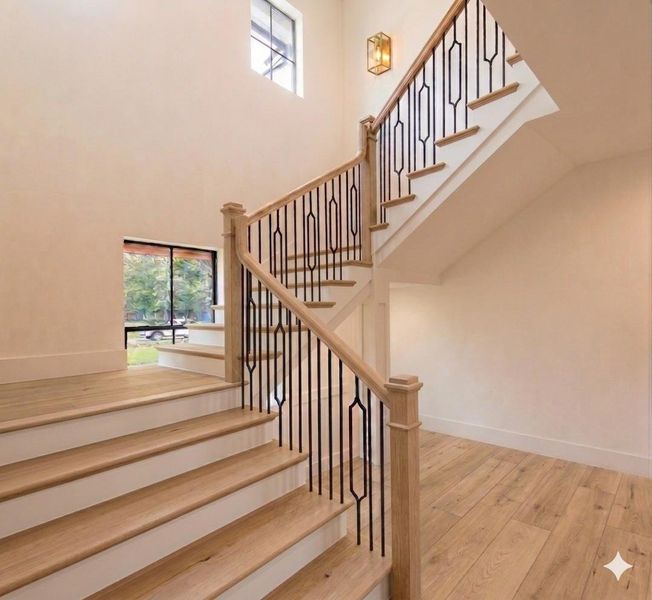 White oak statement staircase with custom iron railing, soaring ceilings, and abundant natural light. Virtually Staged. White oak statement staircase with custom iron railing, soaring ceilings, and abundant natural light. Virtually Staged.
