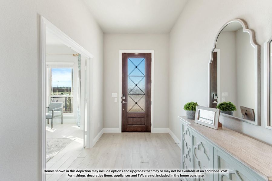Entryway with dark wood glass-panel front door, light hardwood floors, and decorative console table with mirror. Entryway with dark wood glass-panel front door, light hardwood floors, and decorative console table with mirror.