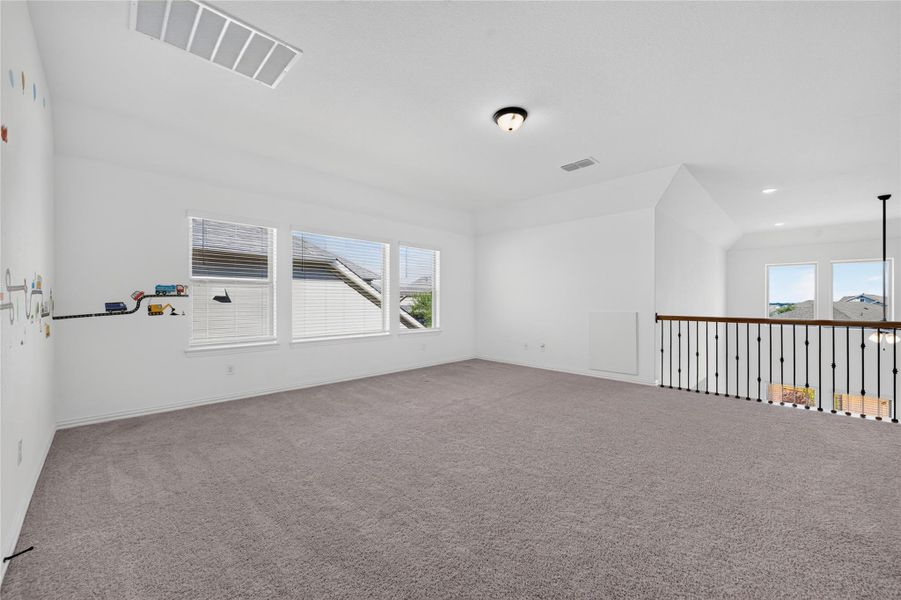 An open upstairs loft area features wall-to-wall carpeting and views over the lower level. An open upstairs loft area features wall-to-wall carpeting and views over the lower level.