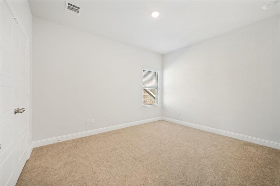 Carpeted room with white walls and a single window featuring horizontal blinds