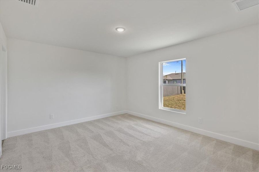 Unfurnished room with light carpet and baseboards