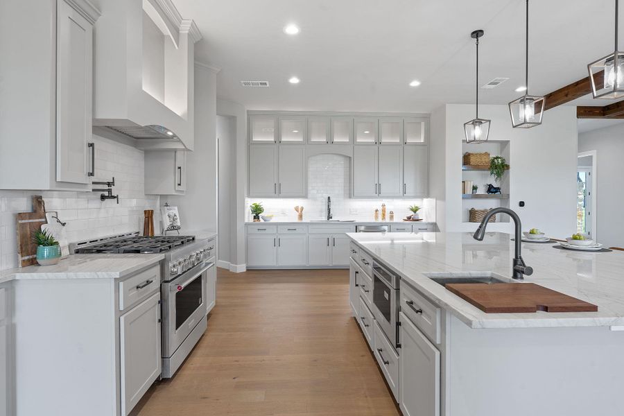 Kitchen with high end stove, wall chimney range hood, recessed lighting, tasteful backsplash, and white cabinets