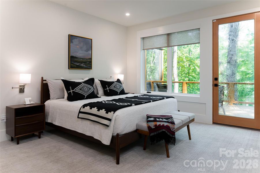 Primary bedroom on the main level, with a door to the open deck