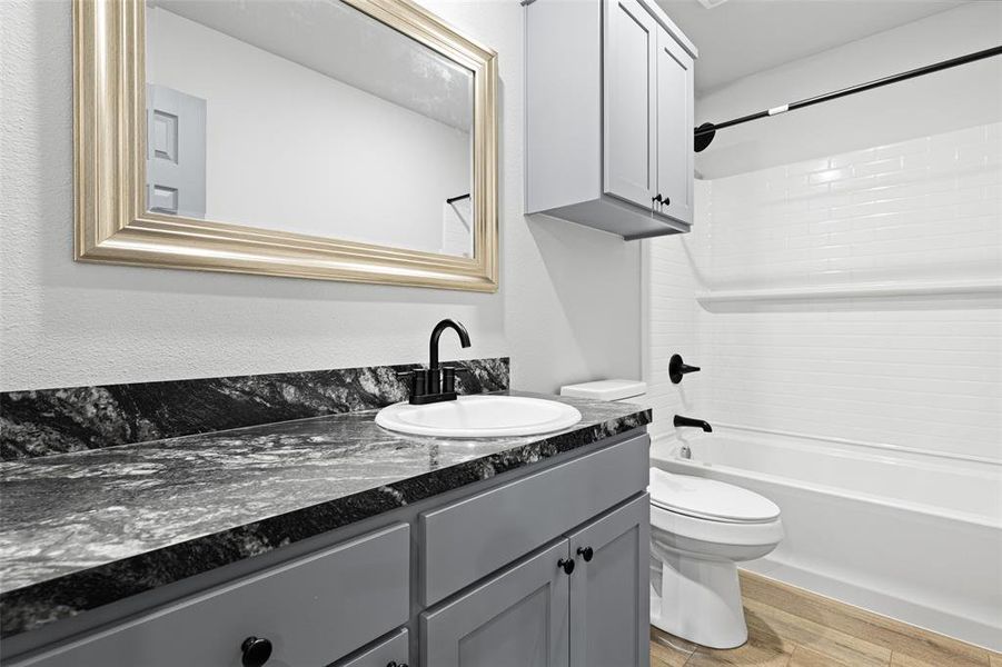 Full bathroom featuring light wood-style floors, shower / washtub combination, and vanity Full bathroom featuring light wood-style floors, shower / washtub combination, and vanity