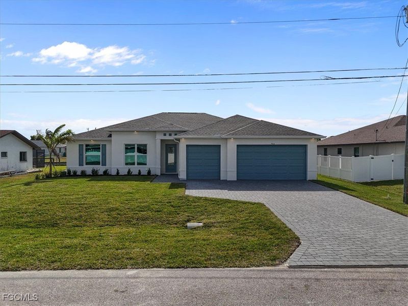 Prairie-style home with stucco siding, decorative driveway, and an attached garage